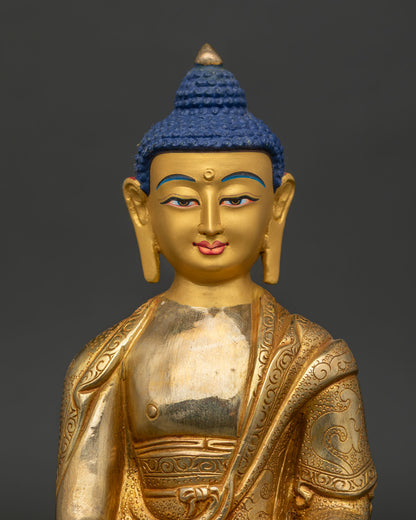 Close up of Amitabha Buddha Statue with gold painted face and hand carved monk robe.