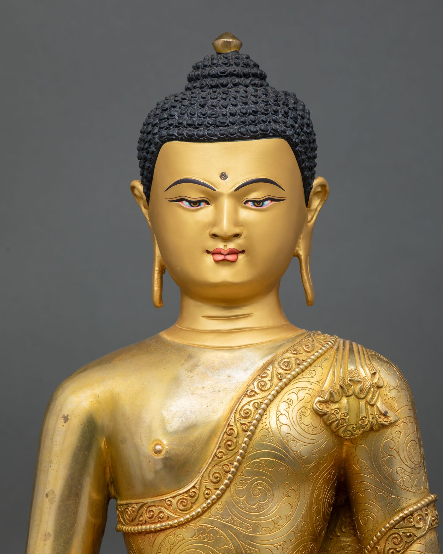 close up of amitabha buddha statue with intricate gold gilded details from nepal