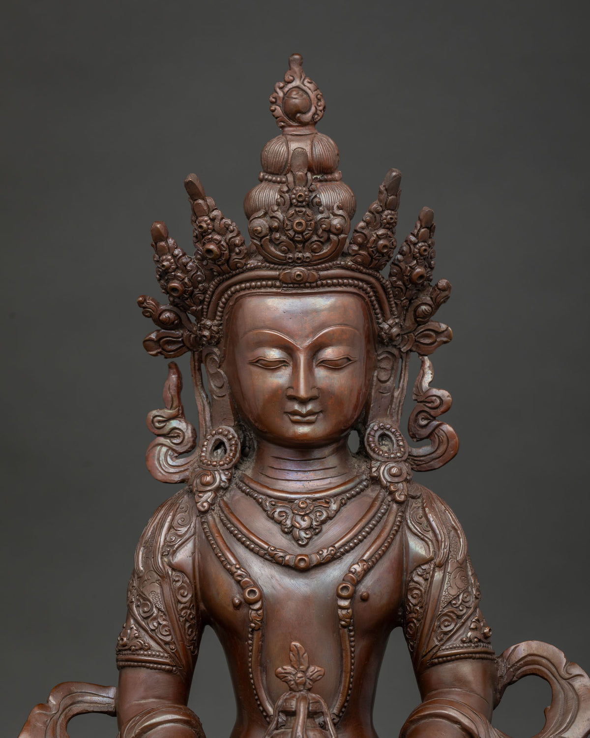 Close up of Amitayus Buddha statue showing detailed copper craftsmanship