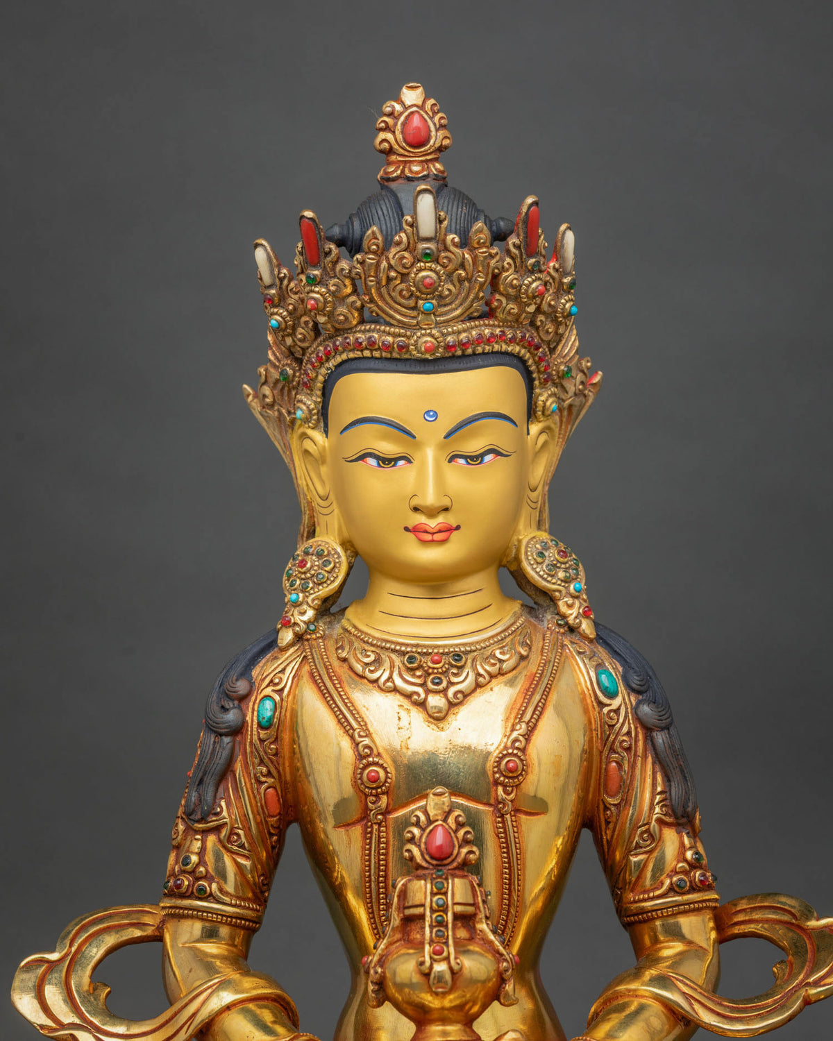 Close-up of Amitayus Statue featuring a serene gold-painted face, five-jewel crown, semi-precious gemstone inlays, and finely carved Buddhist ornaments.