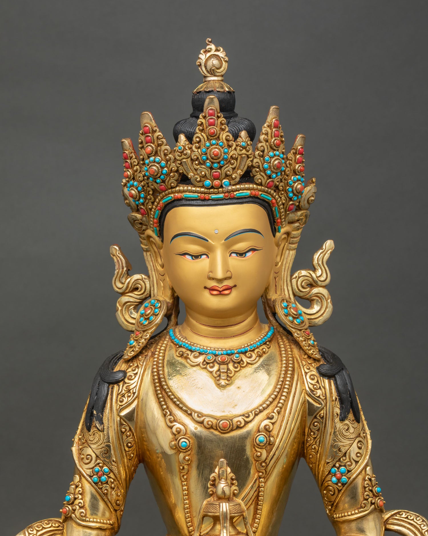 Close-up of Amitayus statue showing intricate gold gilding and semi-precious stones