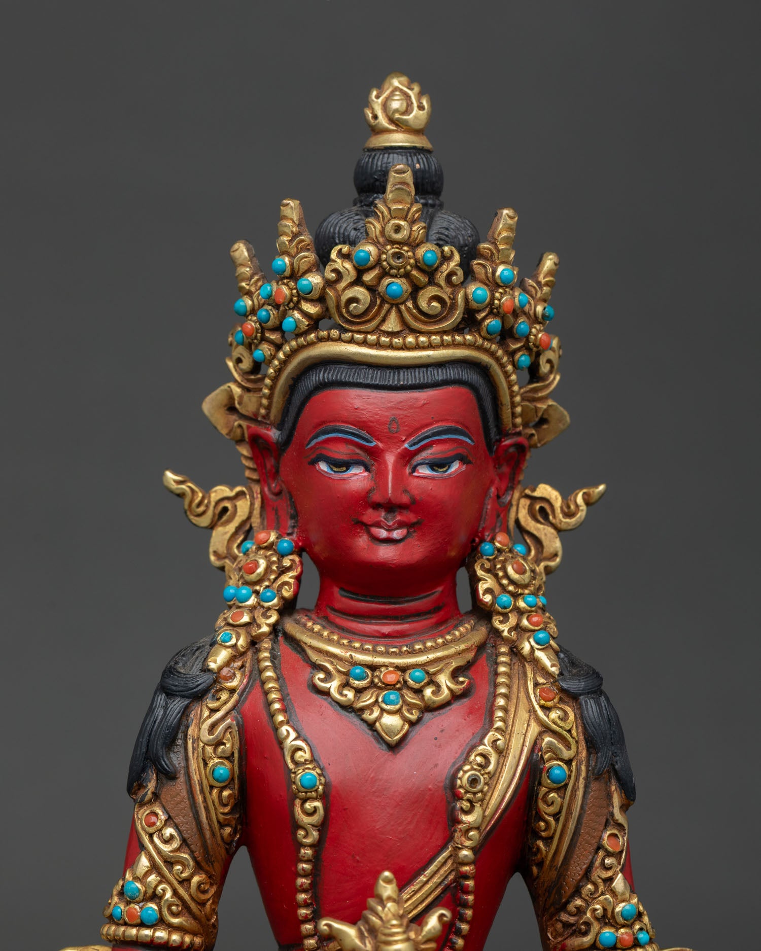 Close up of Amitayus Statue showing serene face, rich colors, and traditional artwork