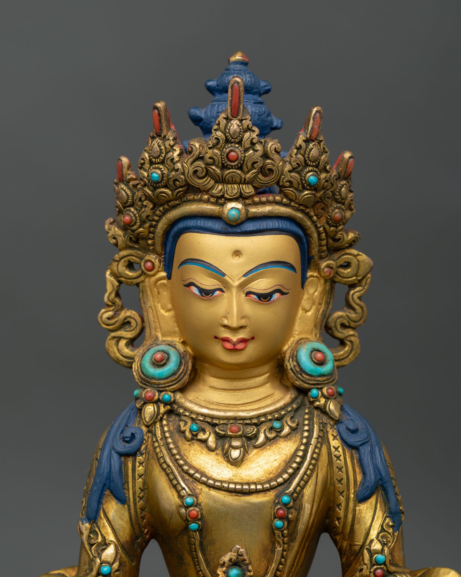 close up of amitayus statue with gold gilding jeweled crown and sacred copper craftsmanship