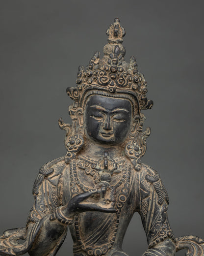 Close-up of antique finish Vajrasattva statue with ornate crown, serene face and vajra in hand