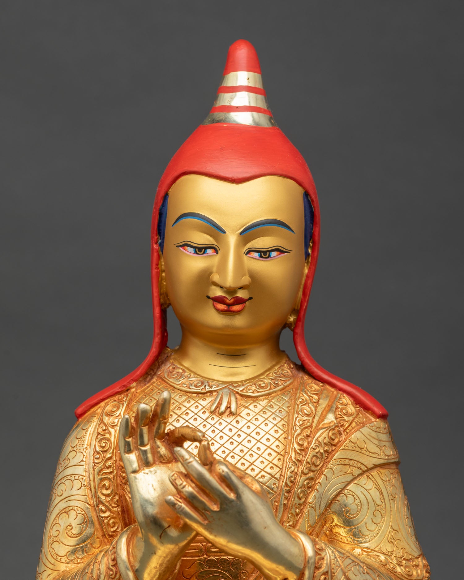 Close up of Atisha Dipankara statue showing gold gilding and intricate robe details