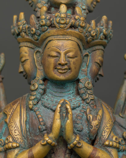 Close-up of Avalokiteshvara's serene gold-painted faces on Chenrezig statue