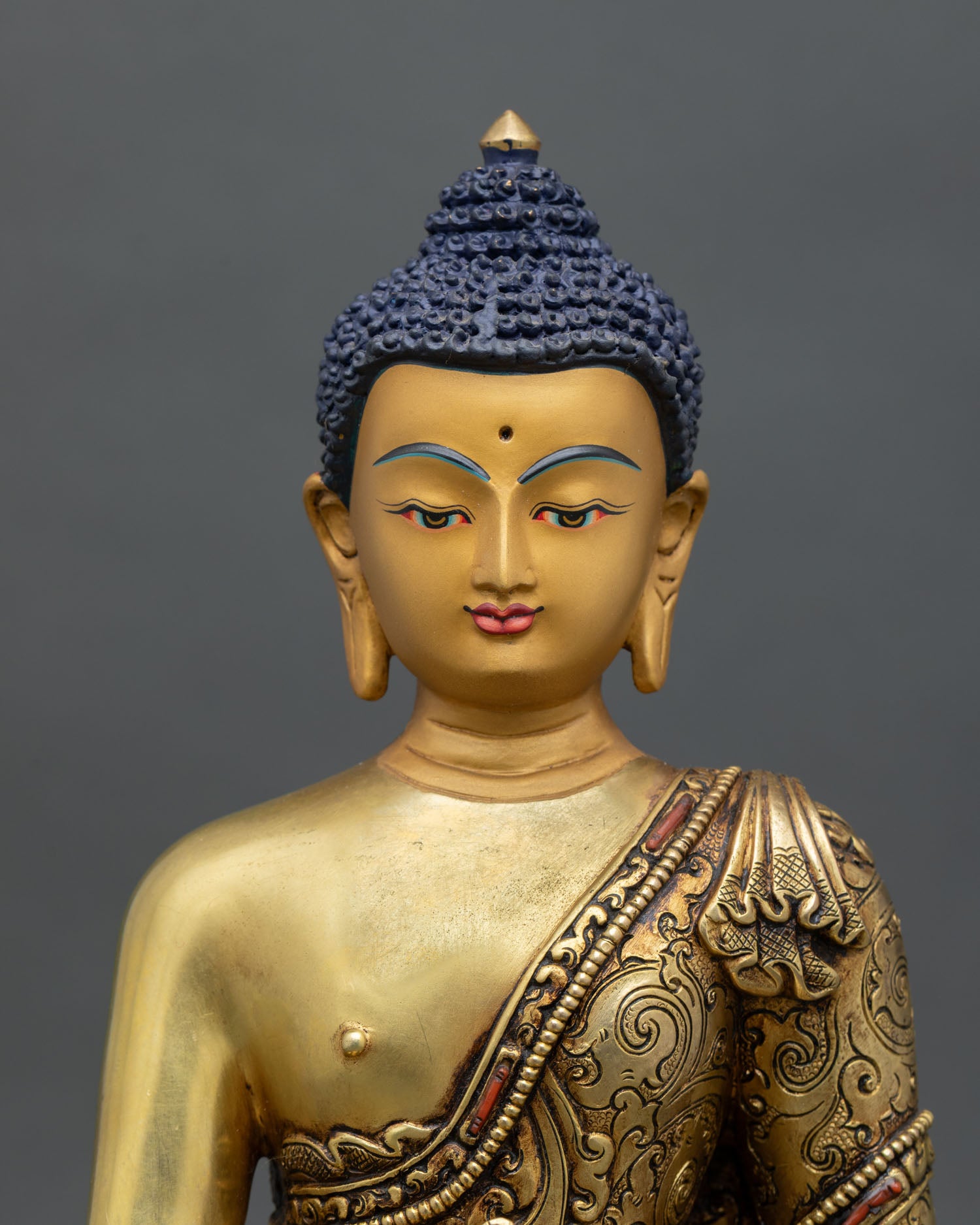 close up of bhaisajyaguru statue with gold detailing and sacred healing bowl