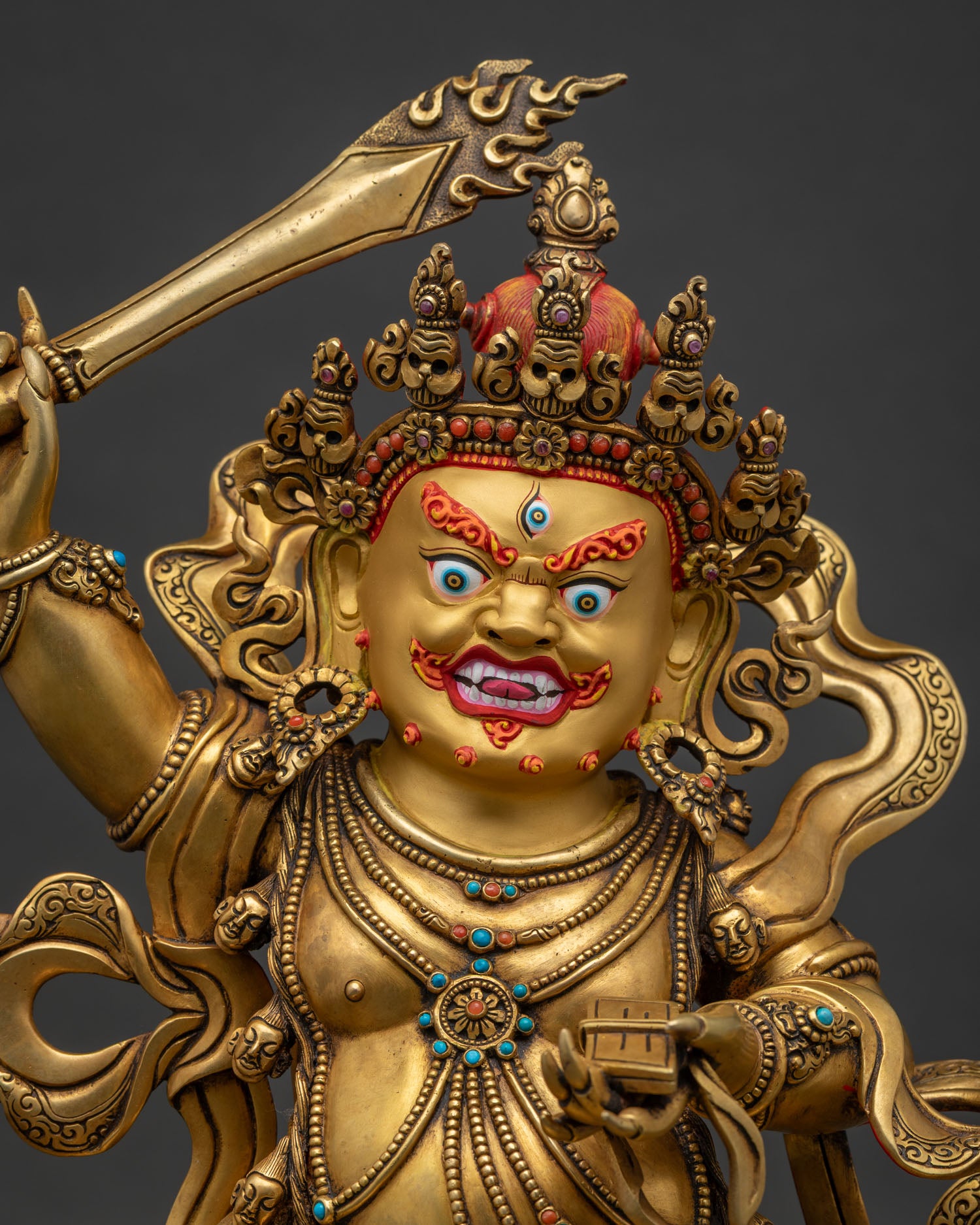 Close-up of Black Manjushri statue showing 24K gold fire-gilding and copper craftsmanship