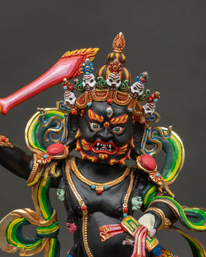 Close-up of Black Manjushri statue showing gold gilded crown and fierce wrathful expression