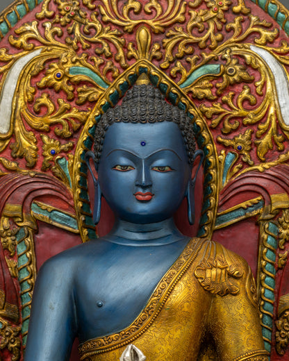 Close up of blue Akshobhya Buddha statue wearing gold robe with silver vajra from Nepal
