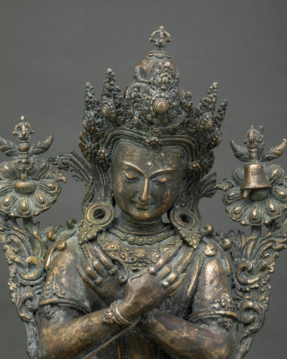 Close-up of bronze Vajradhara statue showing jeweled crown and carved robe detail