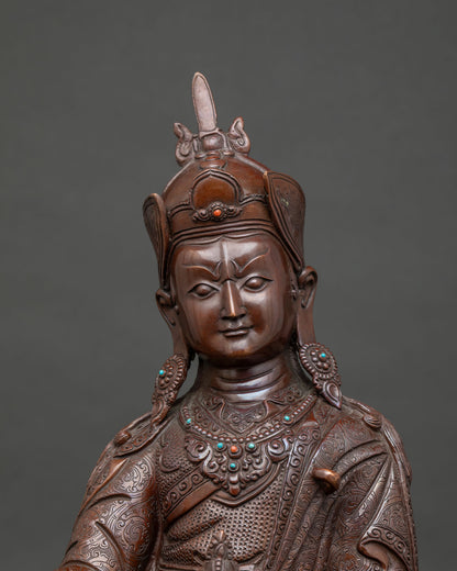 Close up of brown oxidized copper Guru Rinpoche statue with semi-precious stones and lotus pedestal