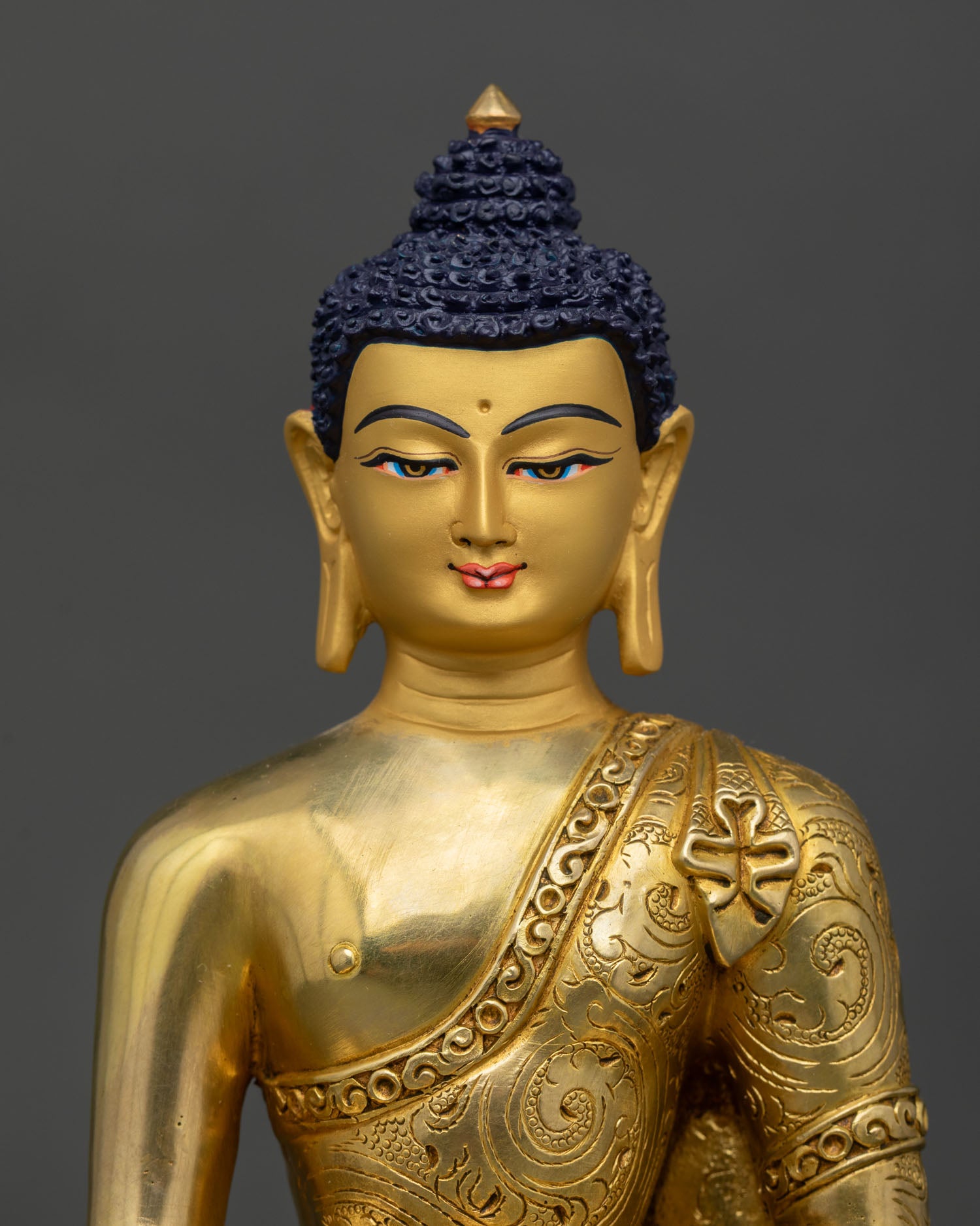 Close up of Buddha face with 24K gold gilded finish and serene enlightened expression