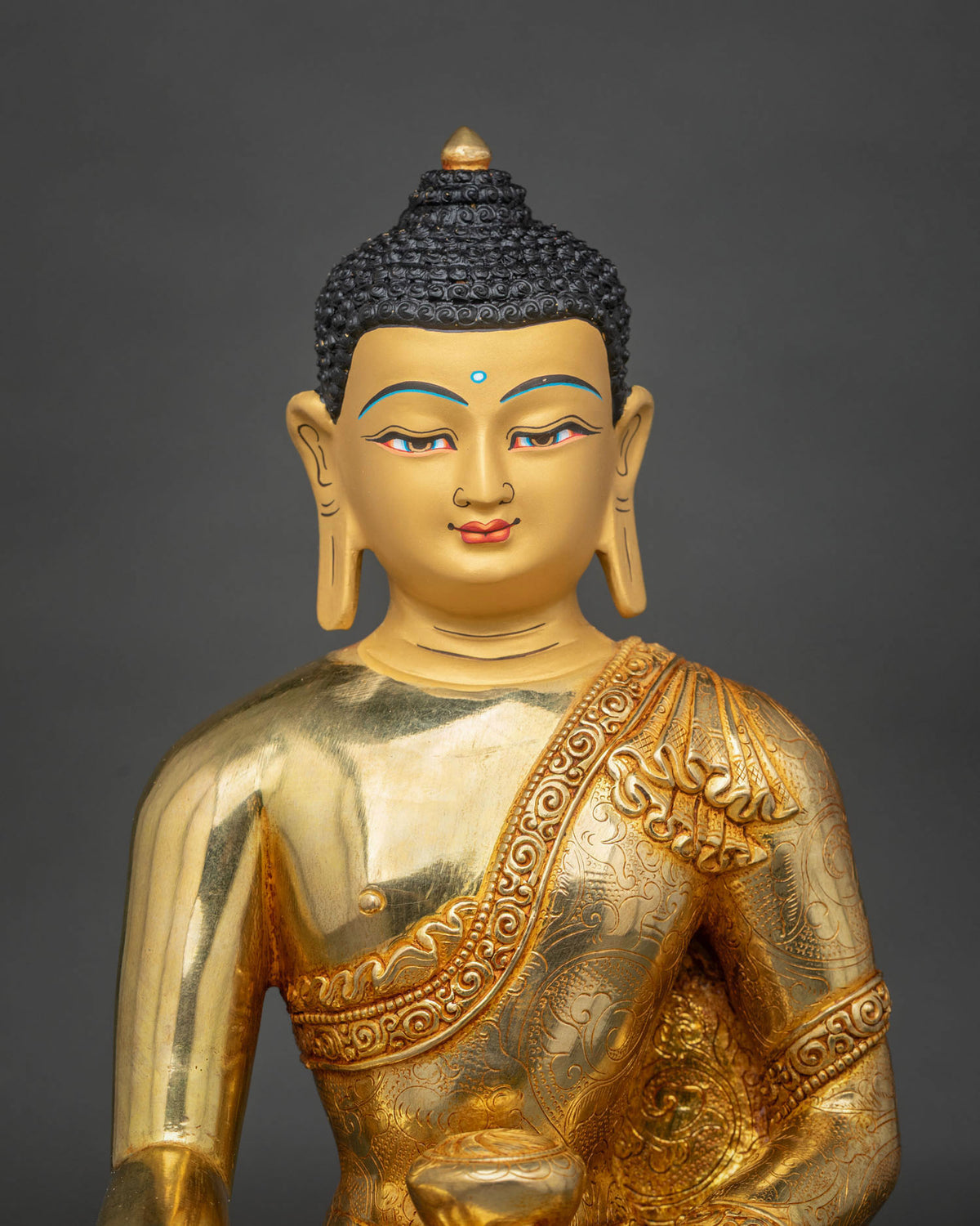 Close-up of Buddha Shakyamuni Statue featuring a peaceful facial expression, finely detailed gold-painted face