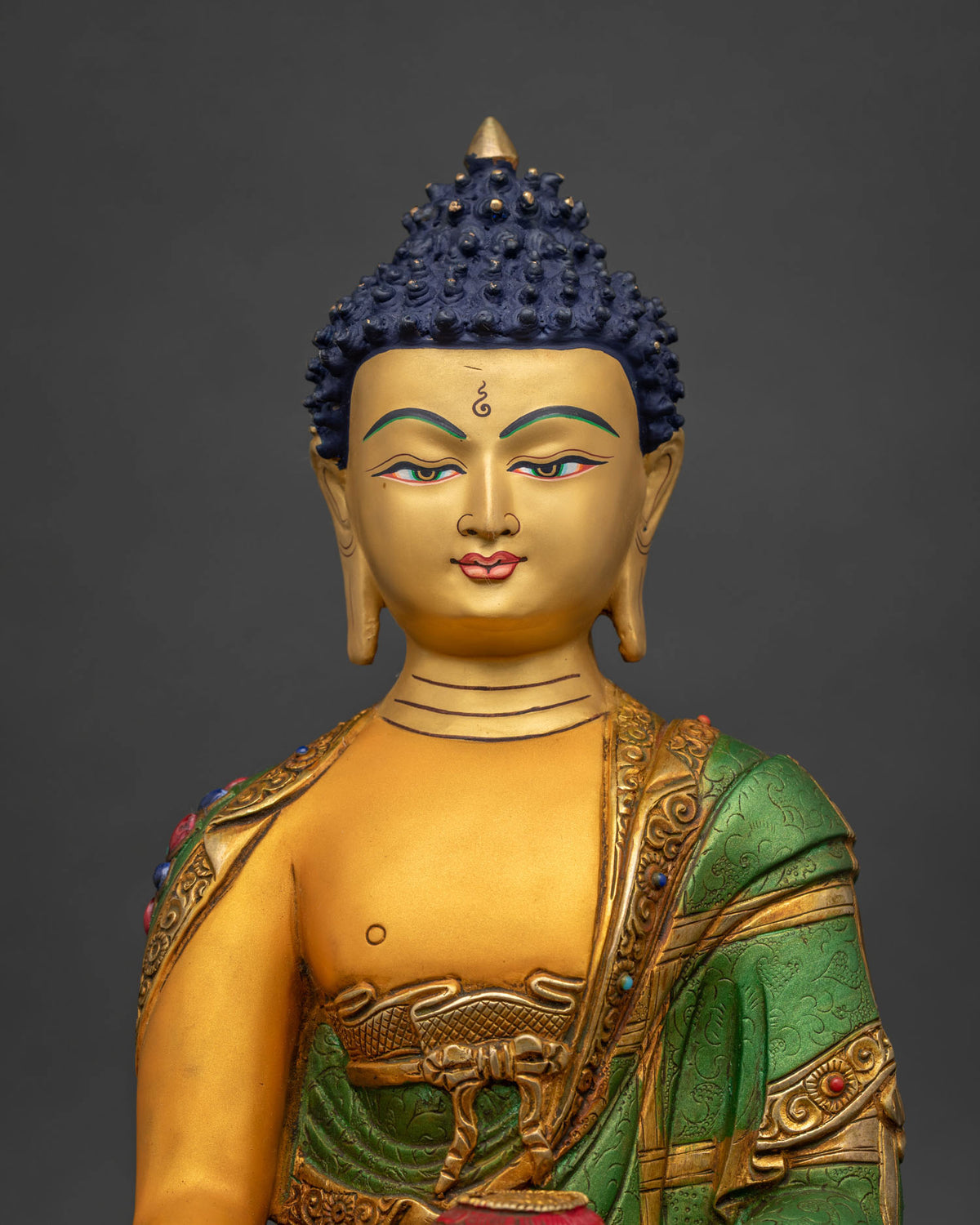 Close-up of Buddha's acrylic robe with semi-precious stone inlay and gold fire-gilding