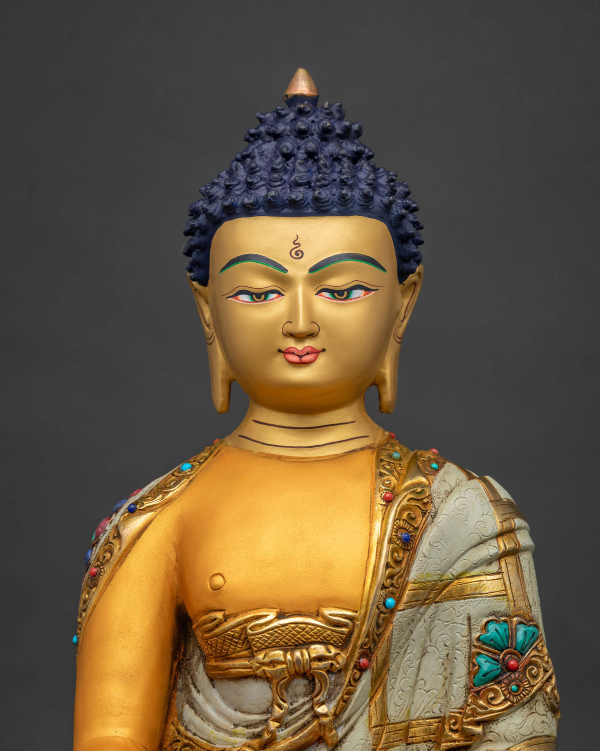 Close-up of Buddha's acrylic robe with turquoise, coral, and lapis semi-precious stone inlay
