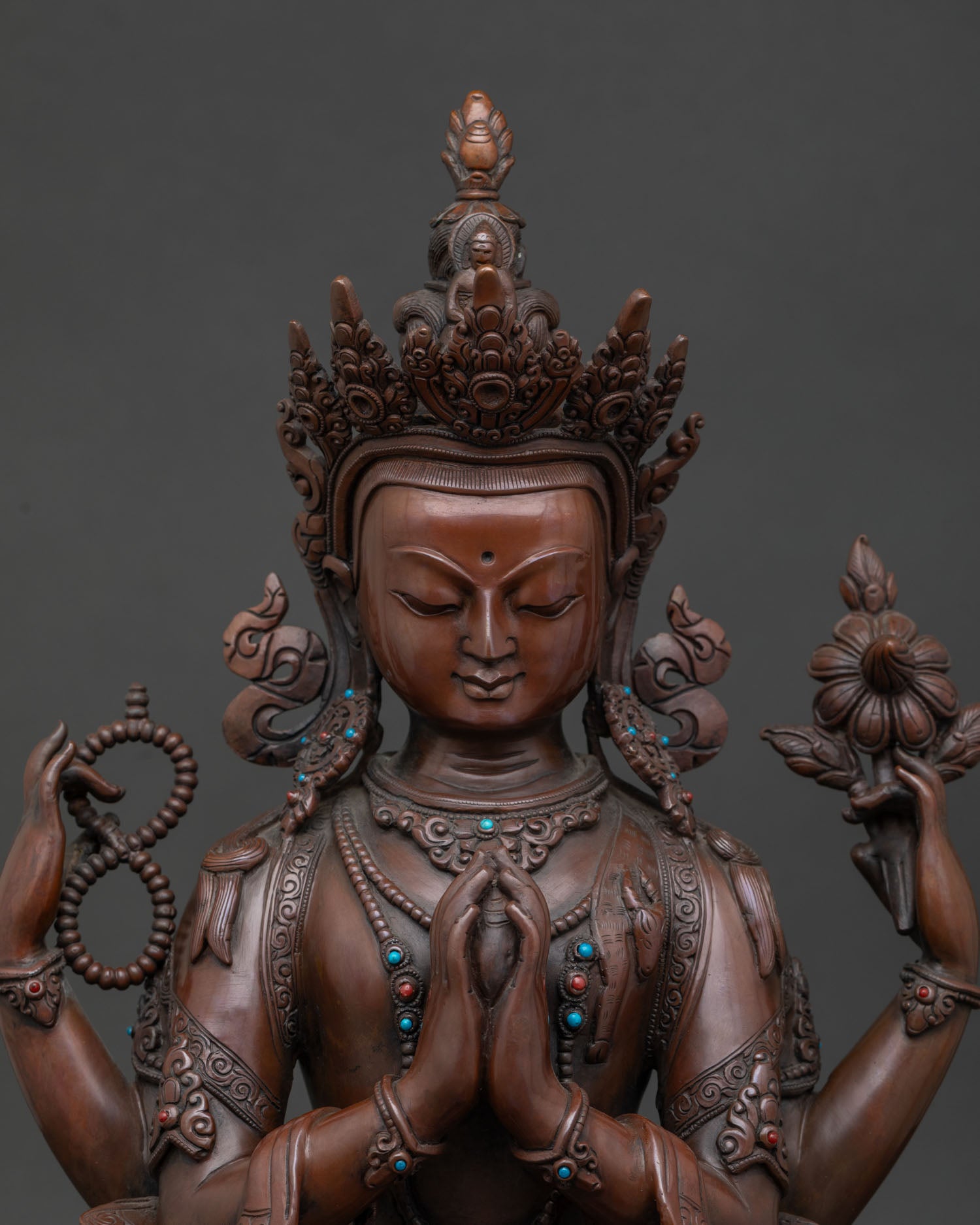 Close up of Chenrezig Avalokiteshvara statue with Anjali Mudra and Amitabha Buddha figure