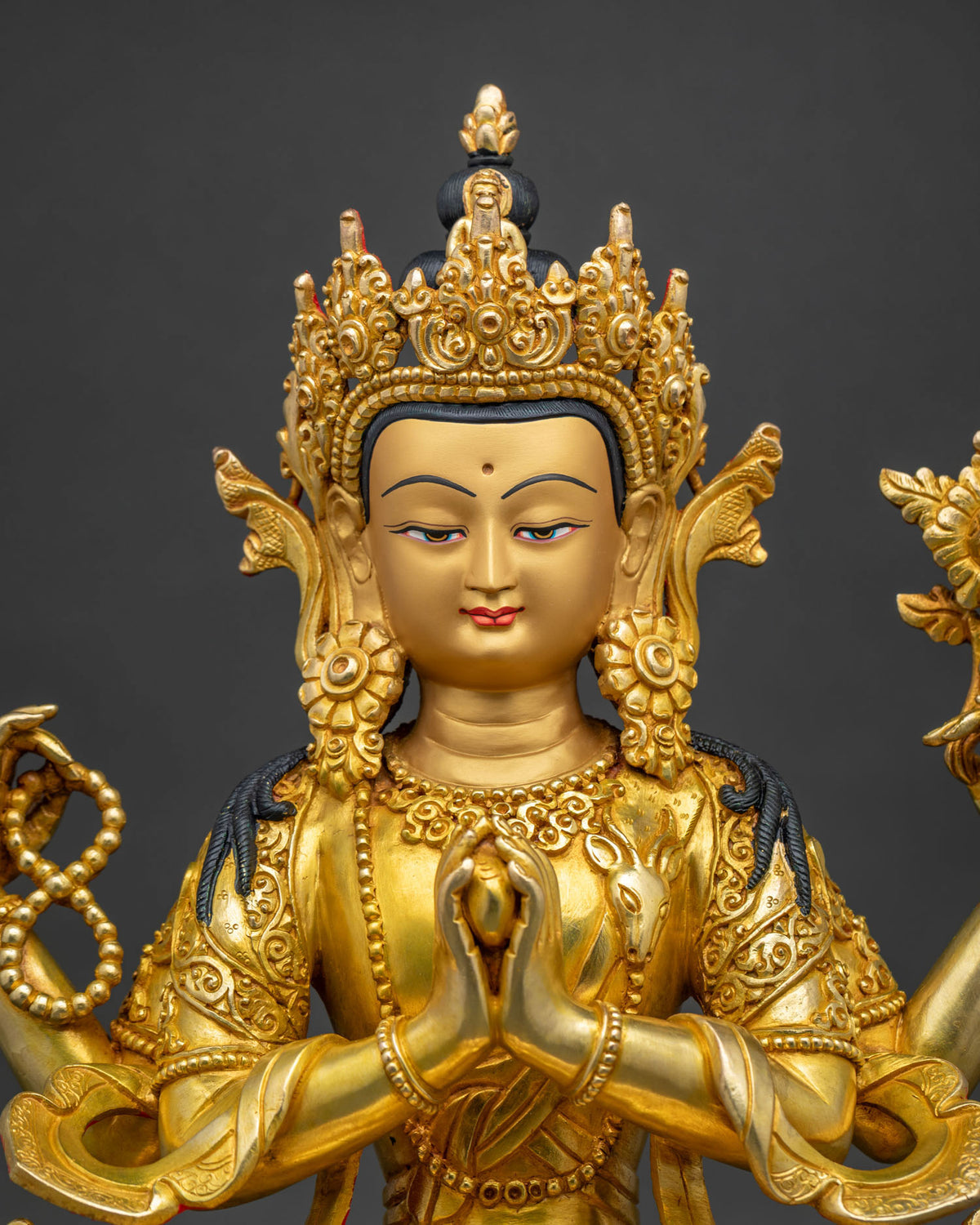 Close-up of Chenrezig statue showing gold gilding and crown detail