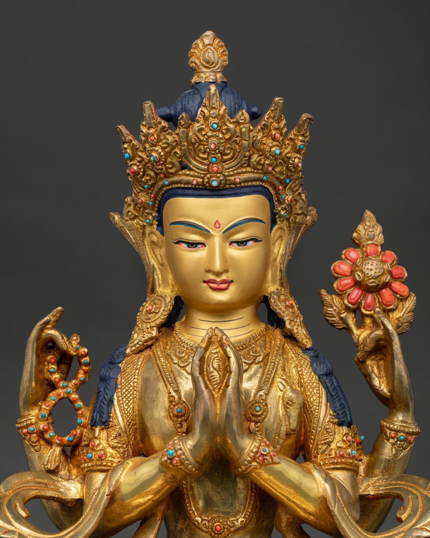 Close-up of Chenrezig Statue showing gold-painted face and intricate stone embellishments