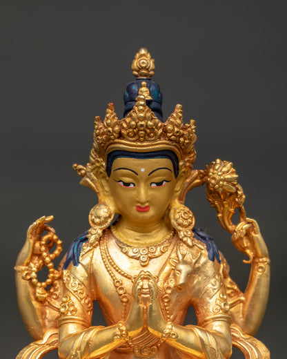 Close up of Chenrezig statue with 24K gold painted face peaceful expression and intricate crown.