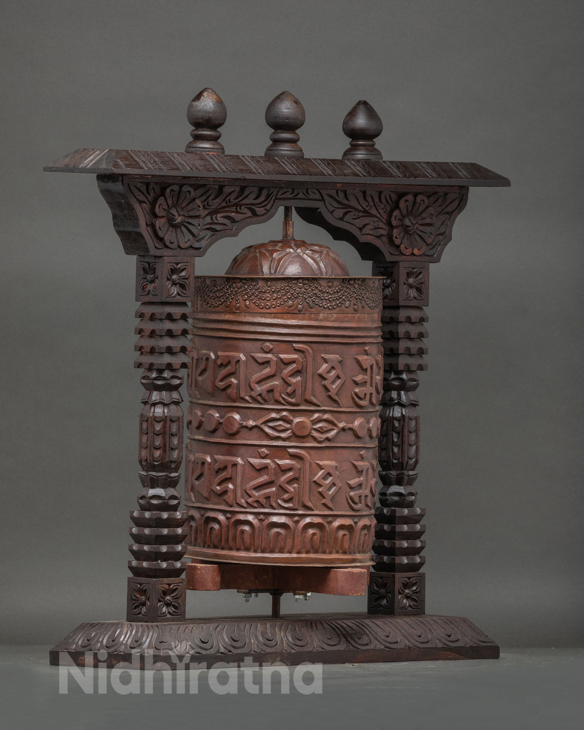 Close up of copper prayer wheel with tibetan mantras and traditional buddhist patterns.