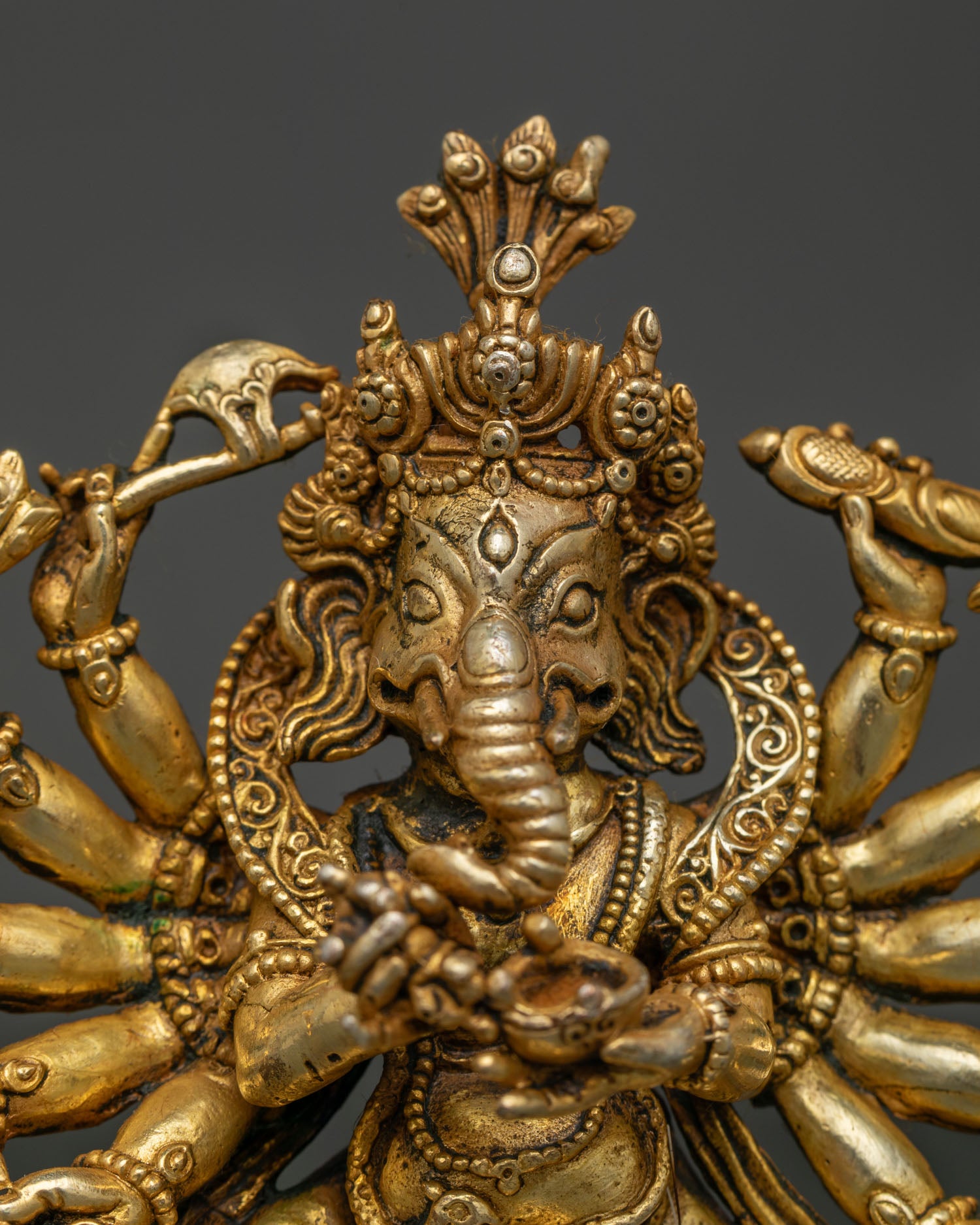 Close Up of Dancing Lord Ganesh with Twelve Arms and Sacred Ritual Objects.