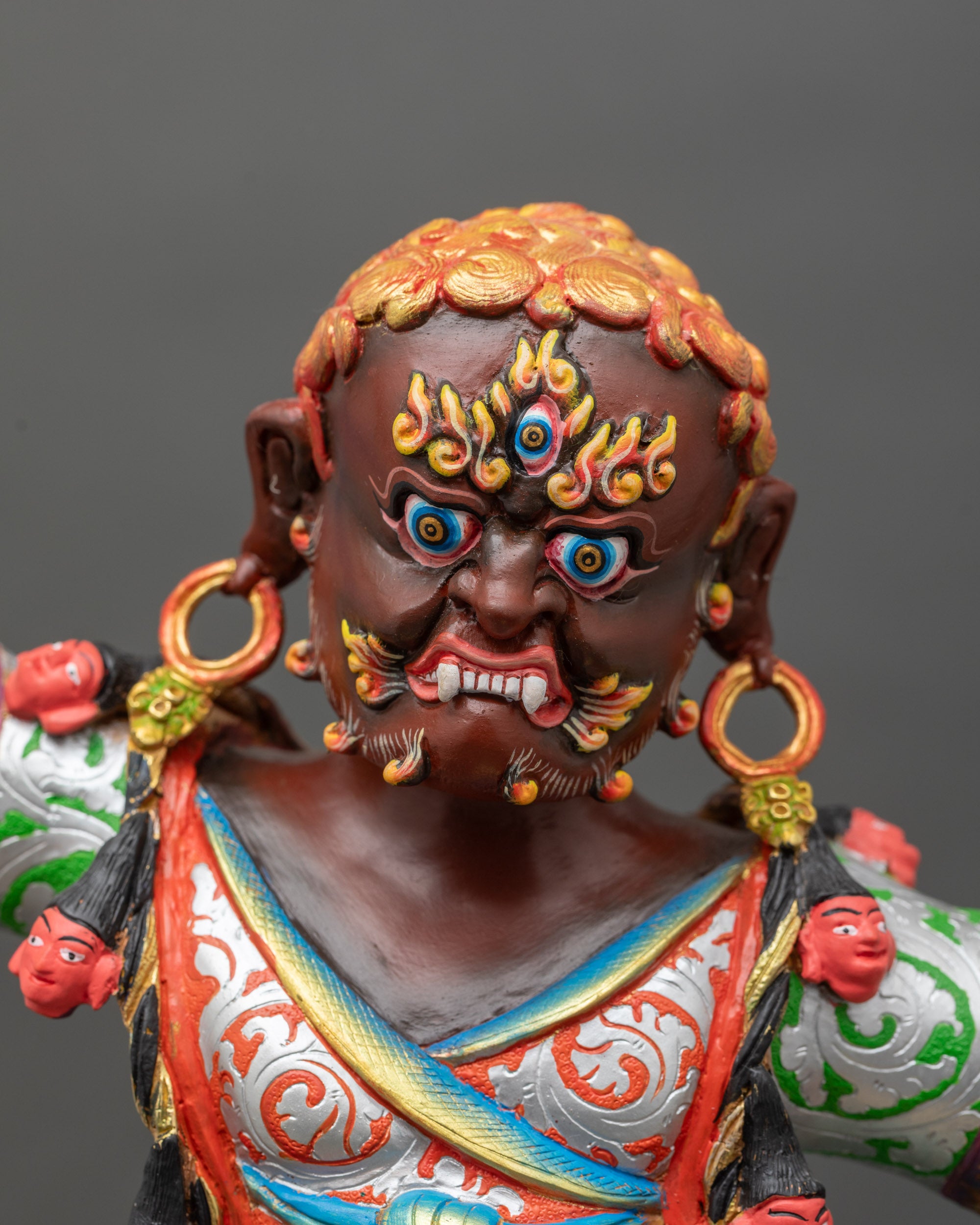 Close-up of Dorje Drolo statue with halo, vibrant acrylic colors on copper sculpture