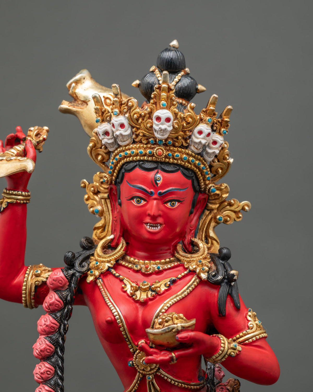 Close-up of Dorje Phagmo statue face with five-skull crown, third eye, and golden sow’s head, Nepal