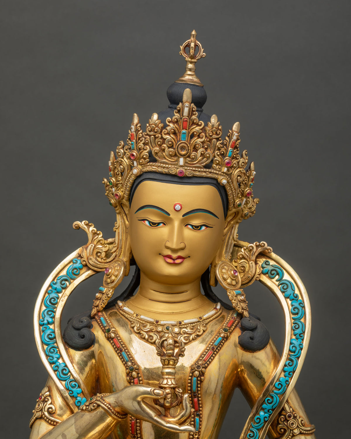 Close up of Dorje Sempa copper statue holding vajra and bell on lotus throne