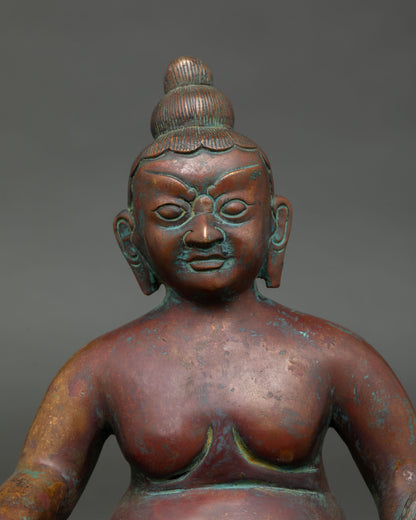 close-up of dzambhala statue face with detailed copper craftsmanship and antique finish