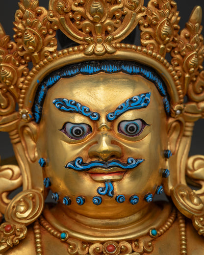 Close-up of Dzambhala statue's face with hand-painted eyes, brows and mustache
