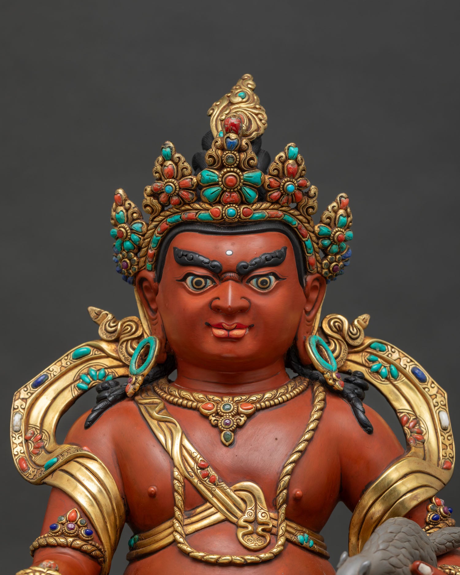 Close-up of Dzambhala Statue showing gold gilded robes and jewel-studded lion throne