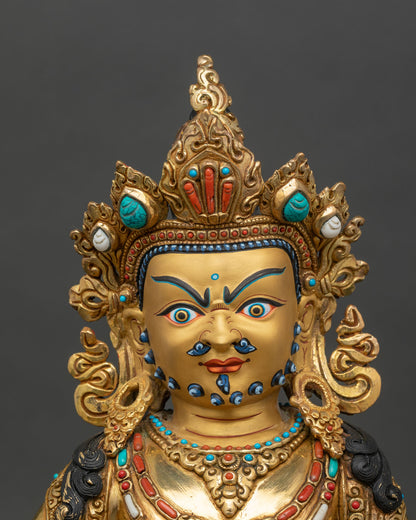 Close-up of Dzambhala statue showing intricate ornaments and gold finish
