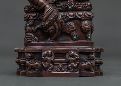 Close-up of Dzambhala’s mongoose and carved lotus seat in oxidized copper finish