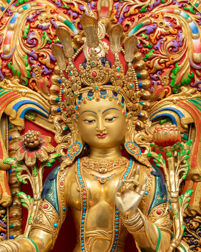 Close-up of enthroned Green Tara statue with ornate prabhavali, coral turquoise gemstone inlays