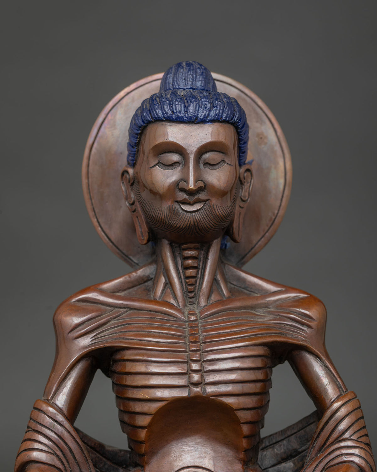 Close up of fasting buddha face with hollow cheeks prominent ribs and calm expression.