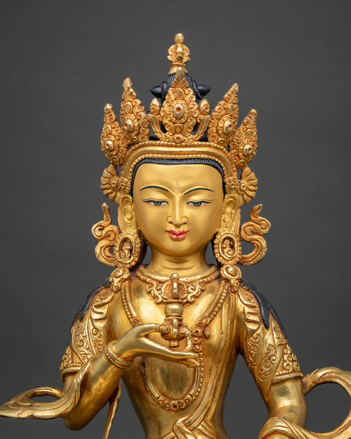 Close up of fire-gilded Vajrasattva statue with Five-Jeweled Crown and dorje held at the heart