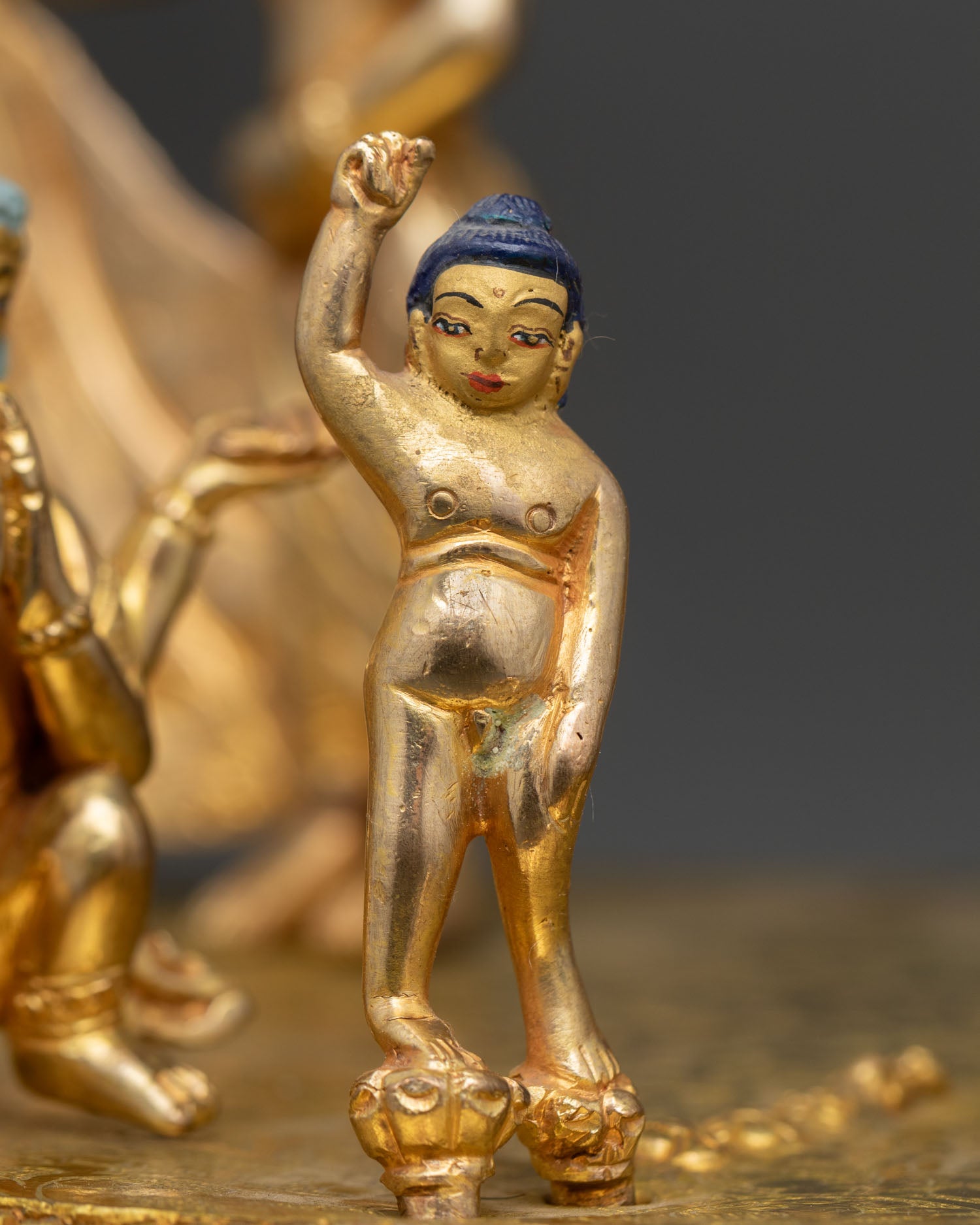 Close up of First Step Buddha Statue with gold painted face and intricate Himalayan crafts
