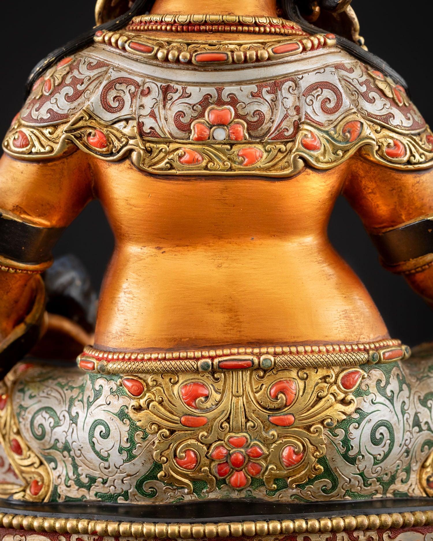 Close-up of floral lower garment detail on Yellow Dzambhala statue
