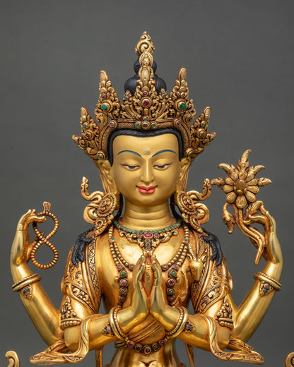 Close up of four-armed Avalokiteshvara statue showing hands in prayer.