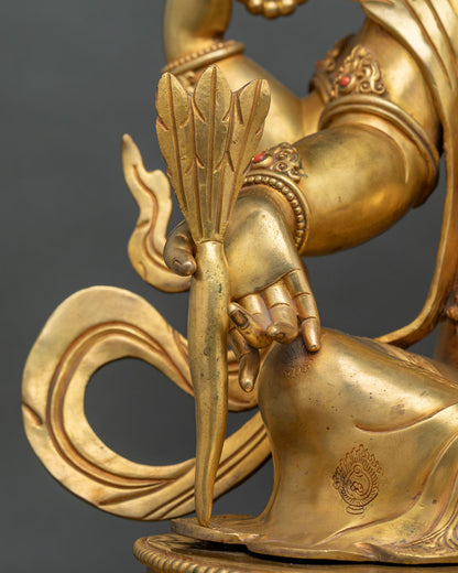 Close-up of Ganesh hand holding a tusk, symbol of abundance, on a gold fire-gilded copper statue