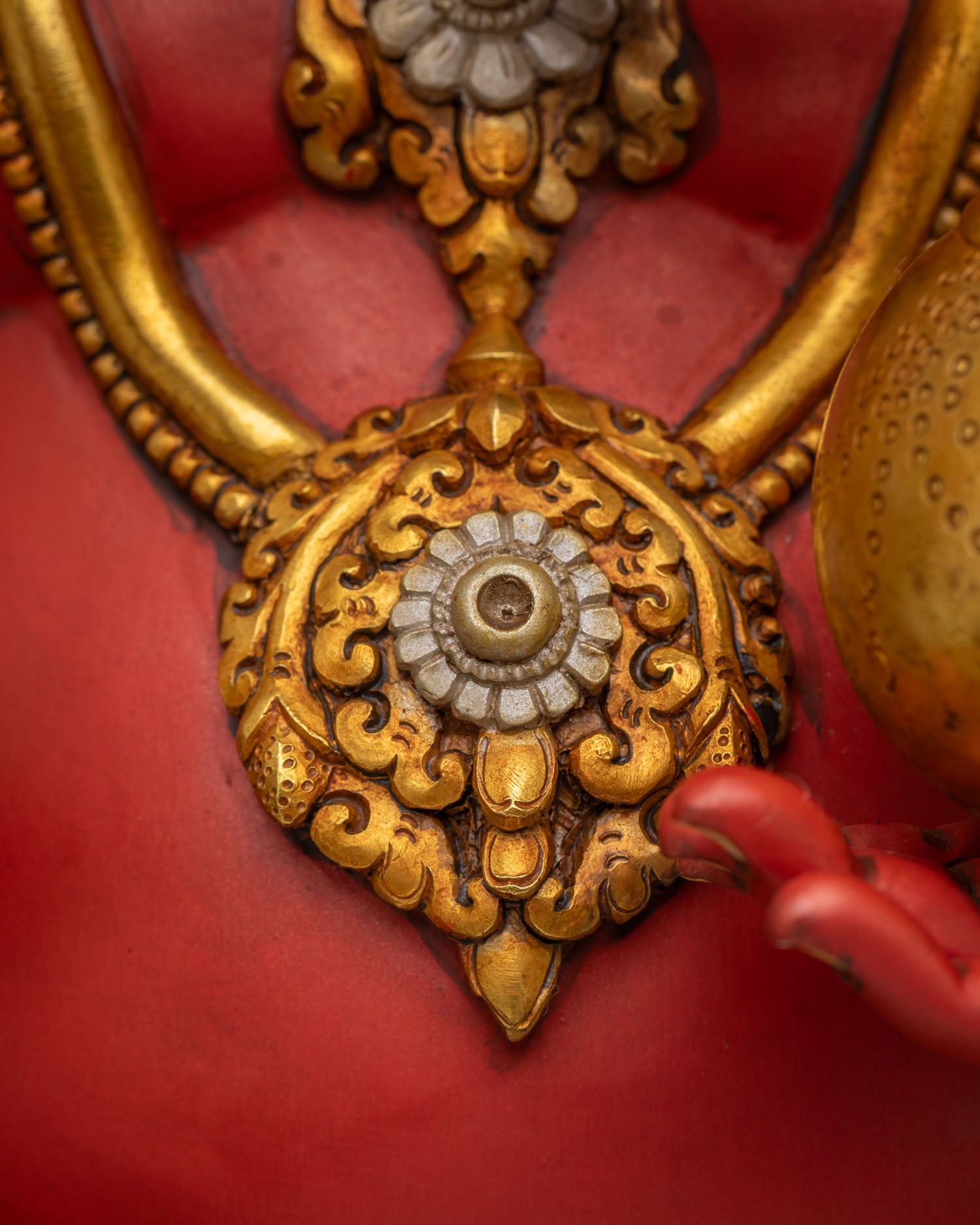 Close-up of Ganesha statue chest necklace with round gold gemstone medallion