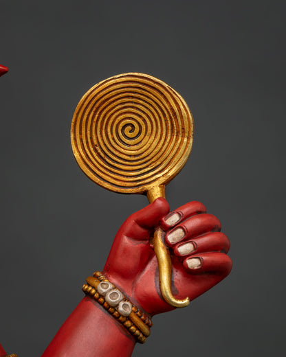 Close-up of Ganesha statue hand holding gold darpana mirror with spiral design