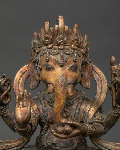 Close-up of Ganesha’s ornamented crown, trunk, and sweets offering in oxidized copper Ganpati statue