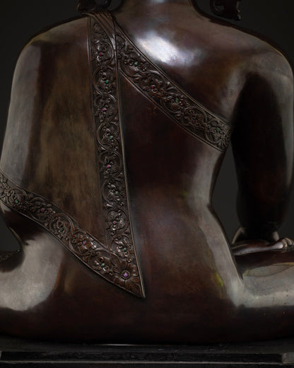 Close-up of gemstone-set floral engraved robe border on copper Shakyamuni Buddha statue