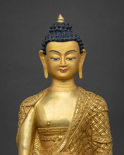 Close up of gold fire-gilded copper Shakyamuni Buddha statue with hand-carved monastic robe