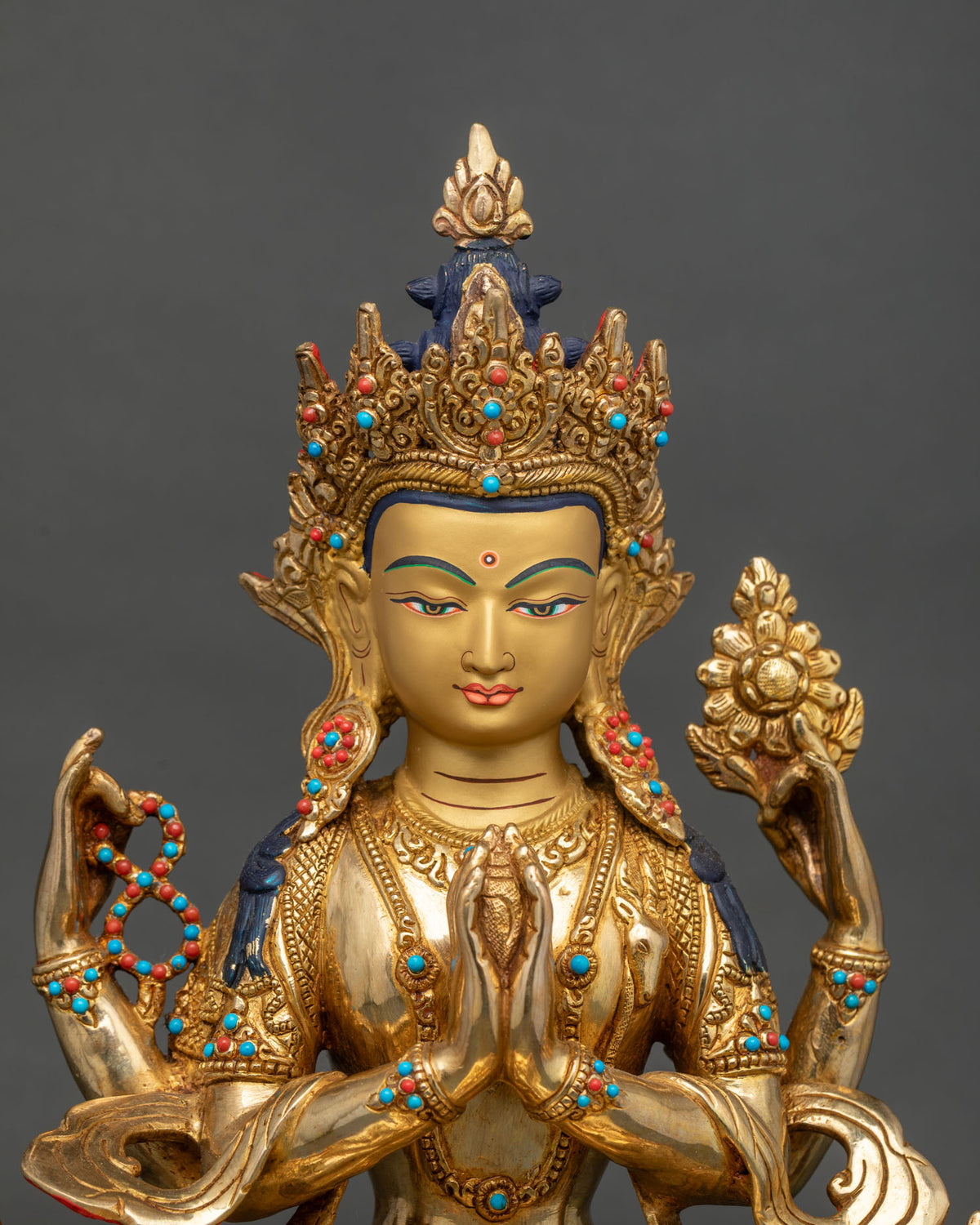 Close-up of gold-fired Chenrezig statue showing jeweled crown and repoussé detail