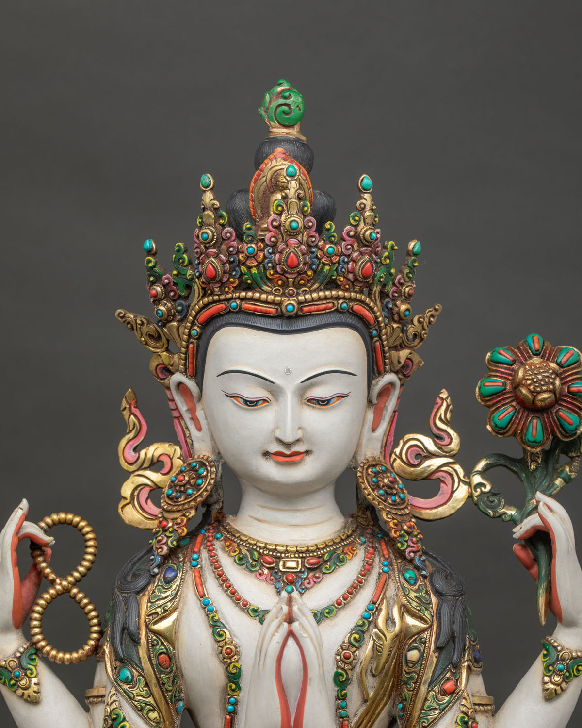 Close up of gold gilded copper Chenrezig statue with lotus and jewel