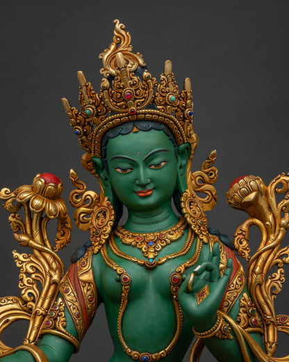 Close-up of gold-gilded Green Tara idol adorned with semi-precious stones
