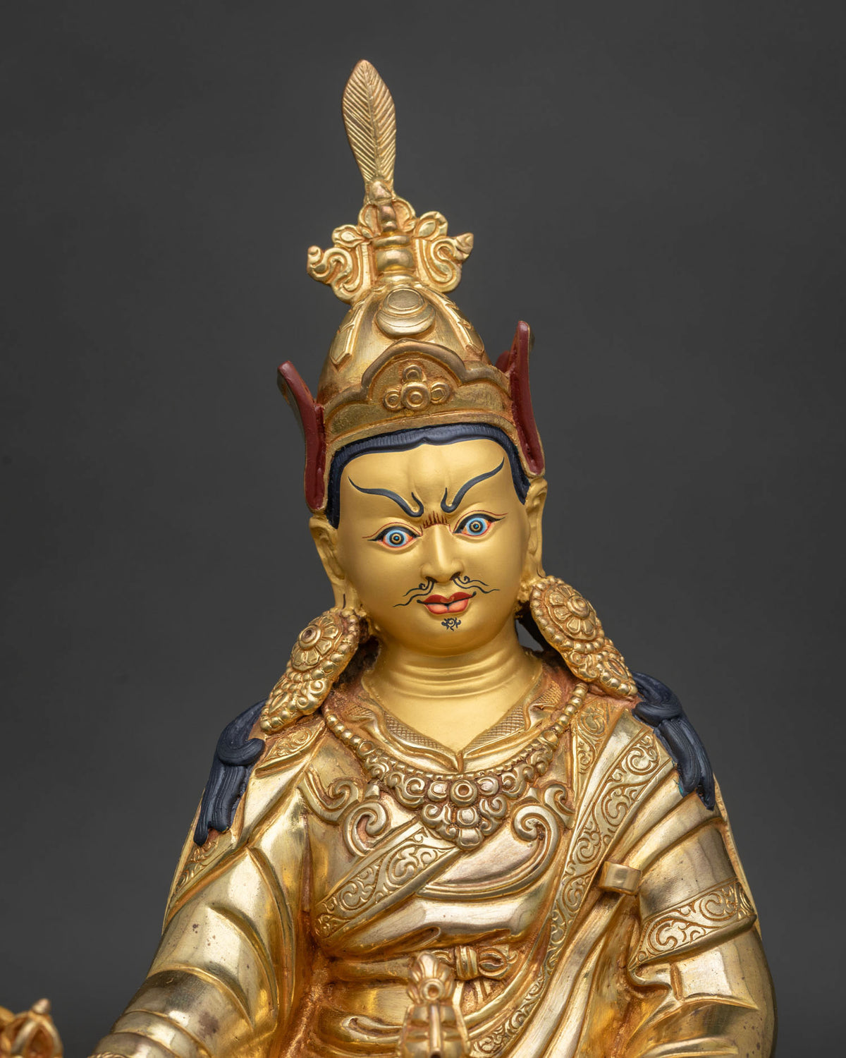 Close-up of gold-gilded Guru Rinpoche statue, genuine Nepal Buddhist sculpture